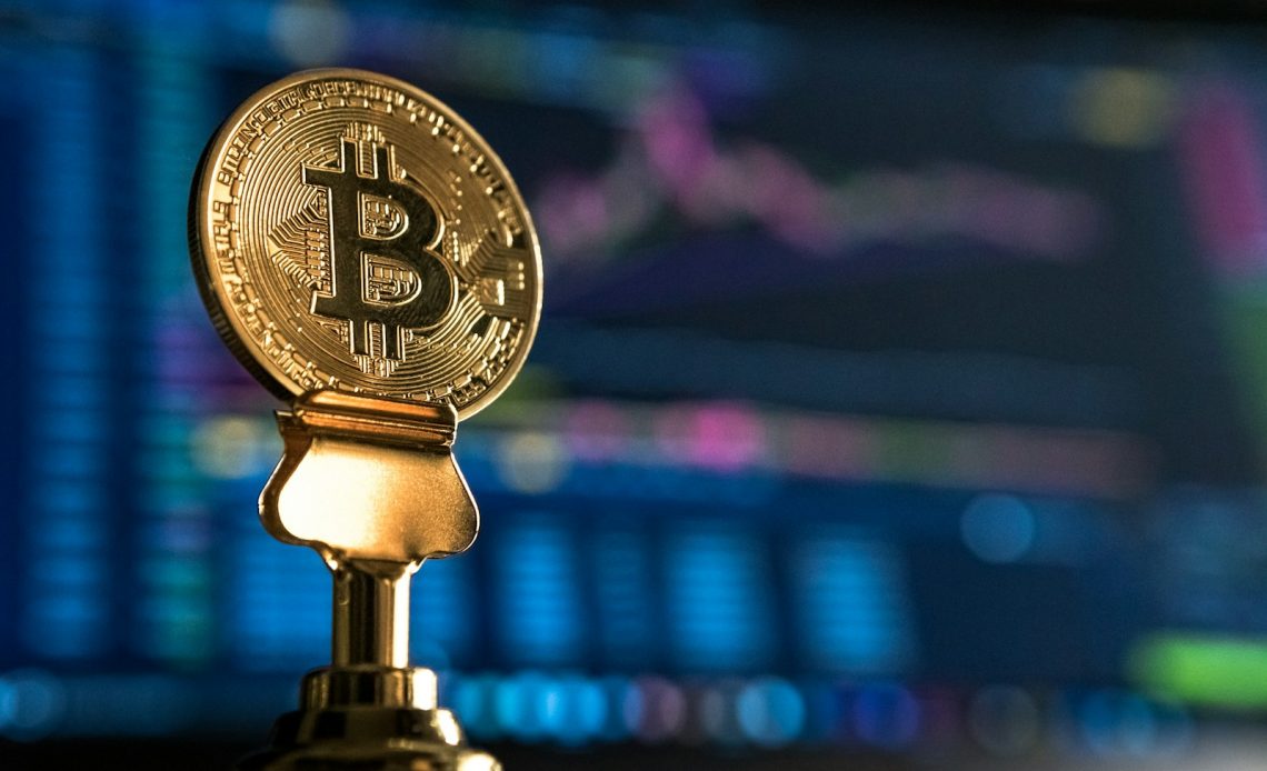 selective focus photo of Bitcoin near monitor