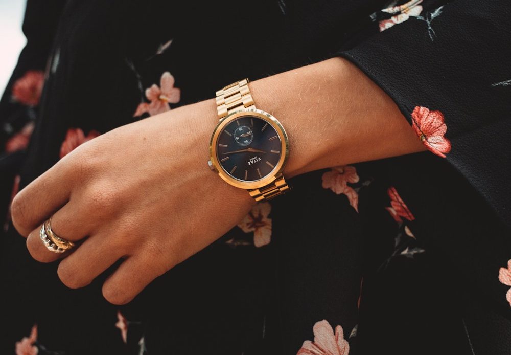 person wearing gold and black analog watch