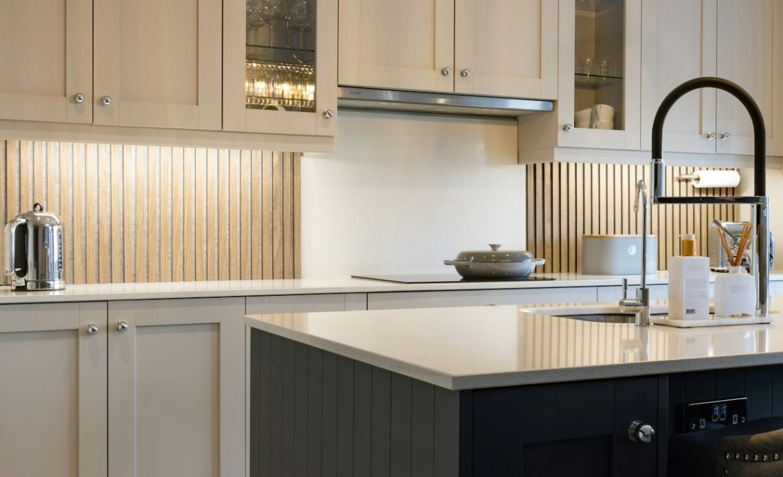a kitchen with white cabinets and a black island