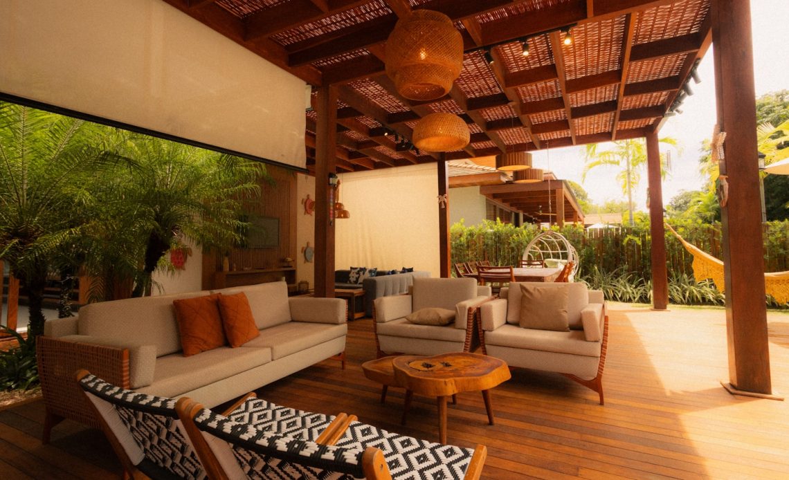 Outdoor living space with sofas and hanging chairs.