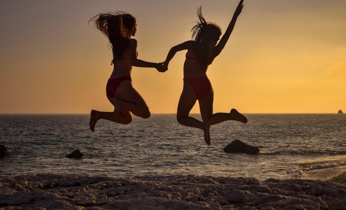 Man op het strand in een zwembroek die uitkijkt over zee