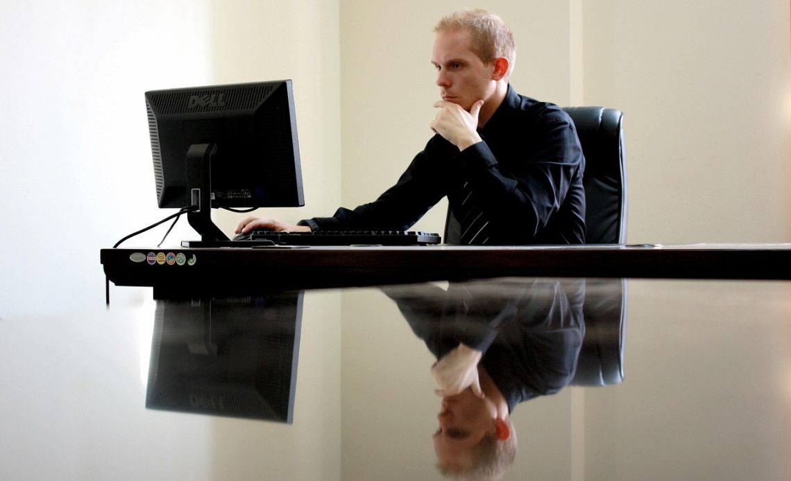 Man die nadenkend achter zijn bureau zit en een beslissing overweegt