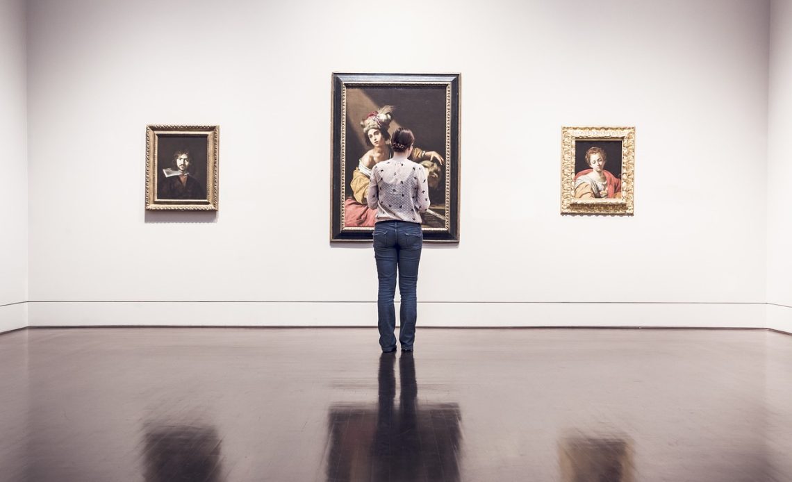 Man die rustig staat te kijken naar een schilderij in een museumzaal